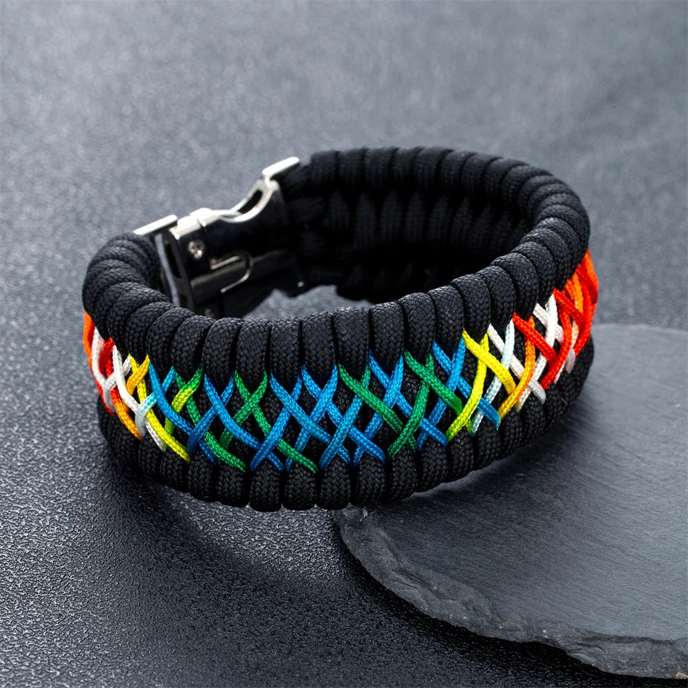 Black paracord bracelet with rainbow woven pattern on a dark surface