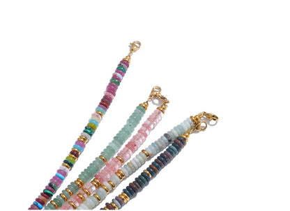 Set of colourful beaded bracelets with gold clasps on a white background
