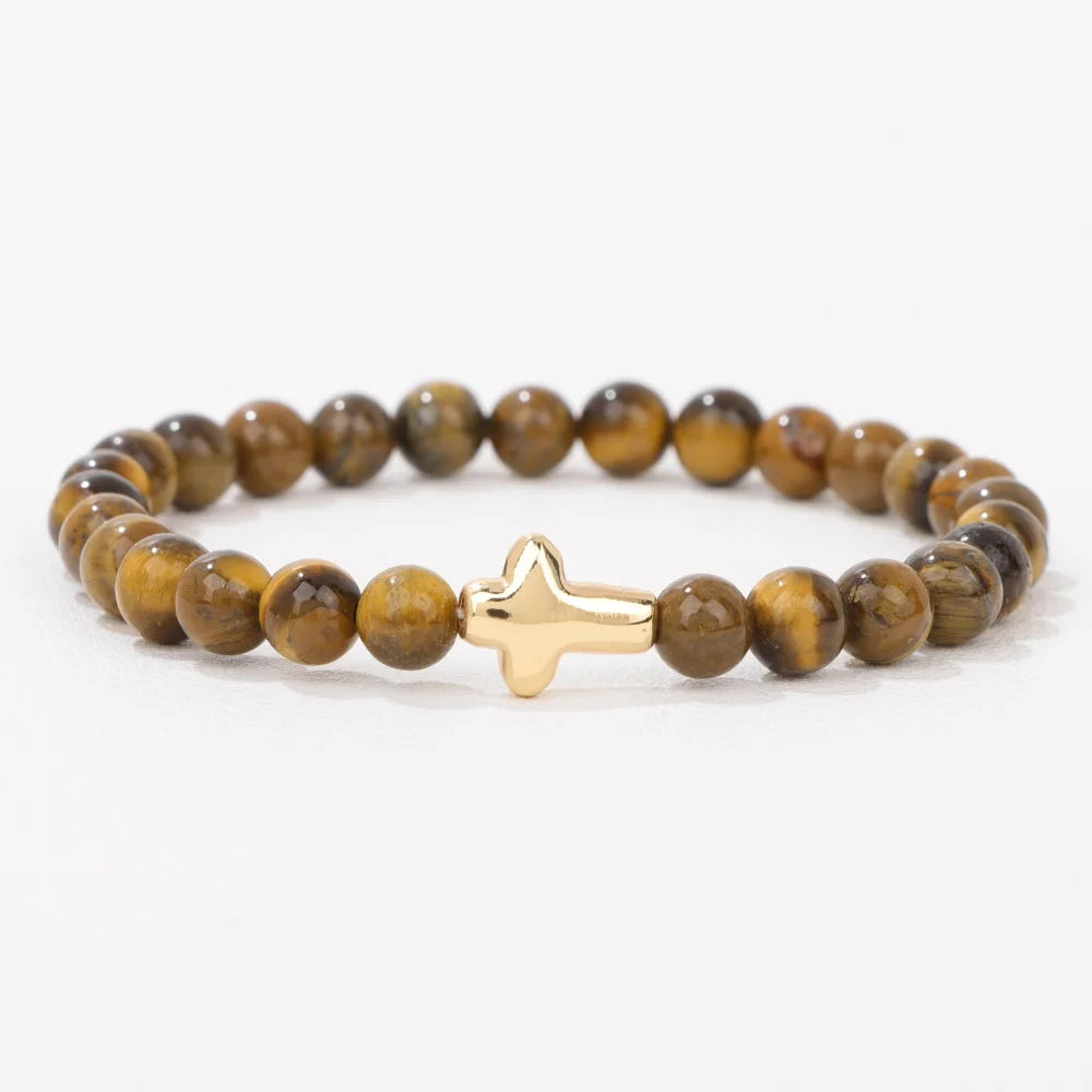 Bracelet with tiger eye beads and a gold cross charm on a white background