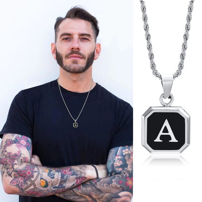 Man wearing a necklace with a black and silver pendant featuring the letter 'A'.