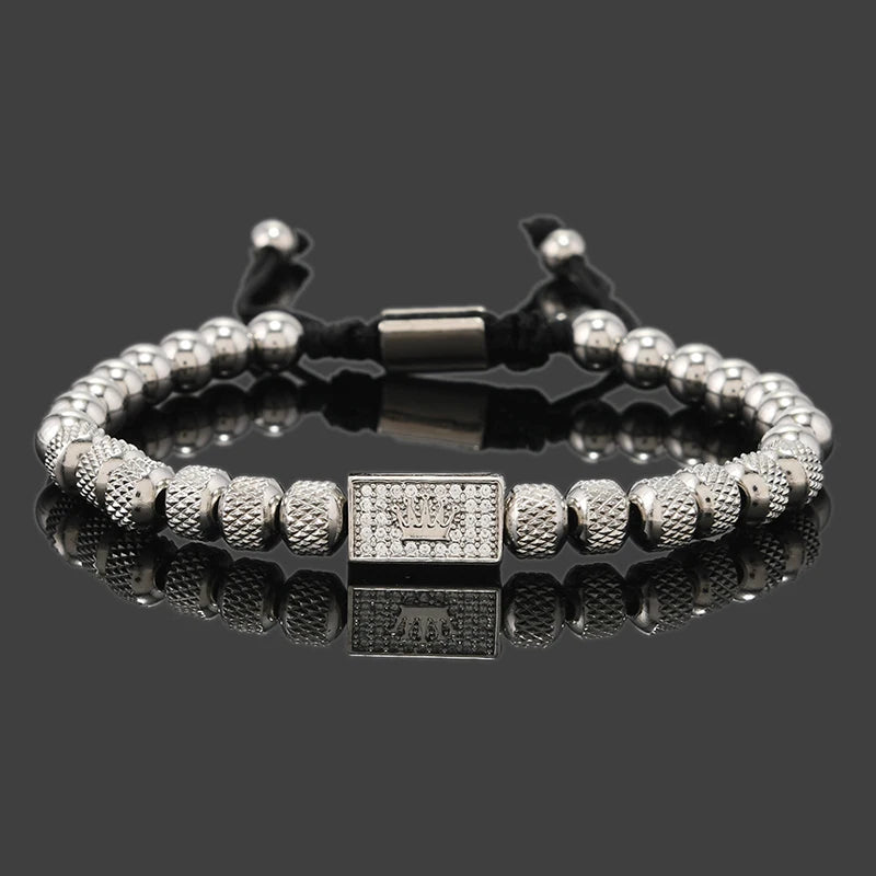Silver beaded bracelet with a clasp on a reflective surface