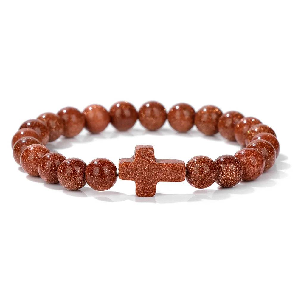 Brown beaded bracelet with a cross charm on a white background