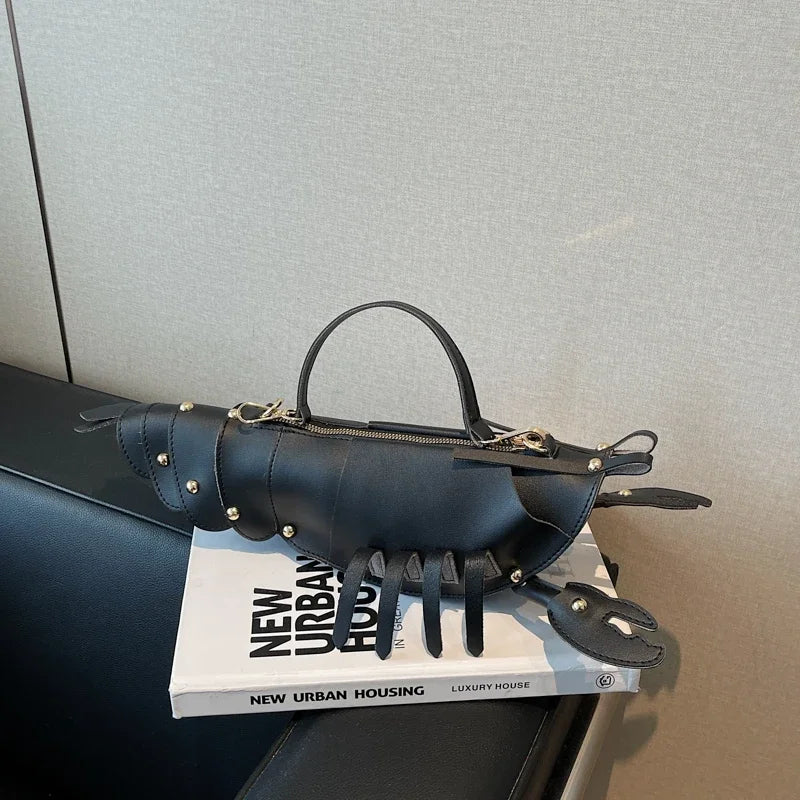 Black handbag with claw-like design on top of a book titled 'New Urban Housing' against a grey wall.