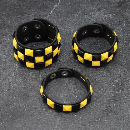 Three black and yellow checkered bracelets on a textured grey surface