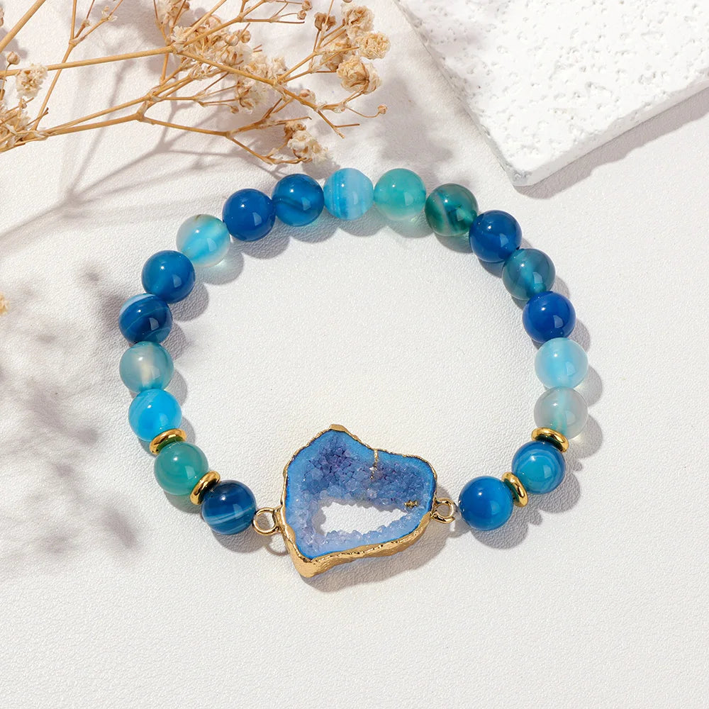 Blue beaded bracelet with a blue agate slice charm on a white background