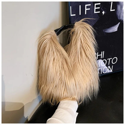 Khaki fluffy handbag held by a hand with a magazine in the background