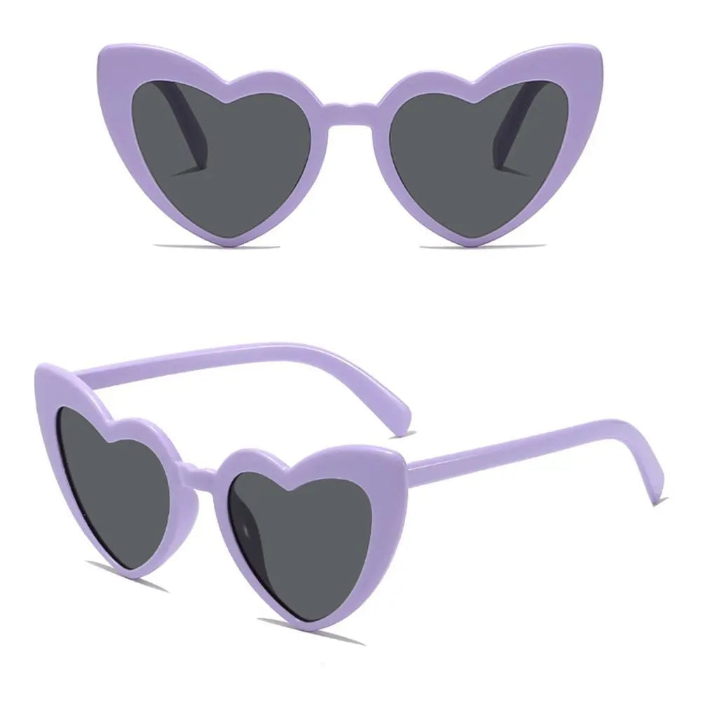 Heart-shaped sunglasses with purple frame and dark lenses on a white background.