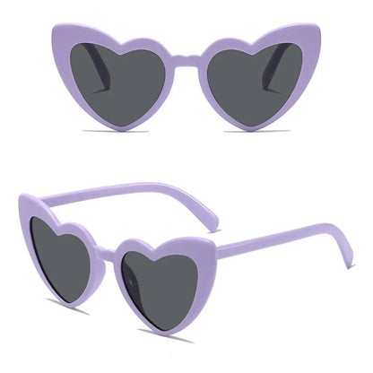 Heart-shaped sunglasses with purple frame and dark lenses on a white background.