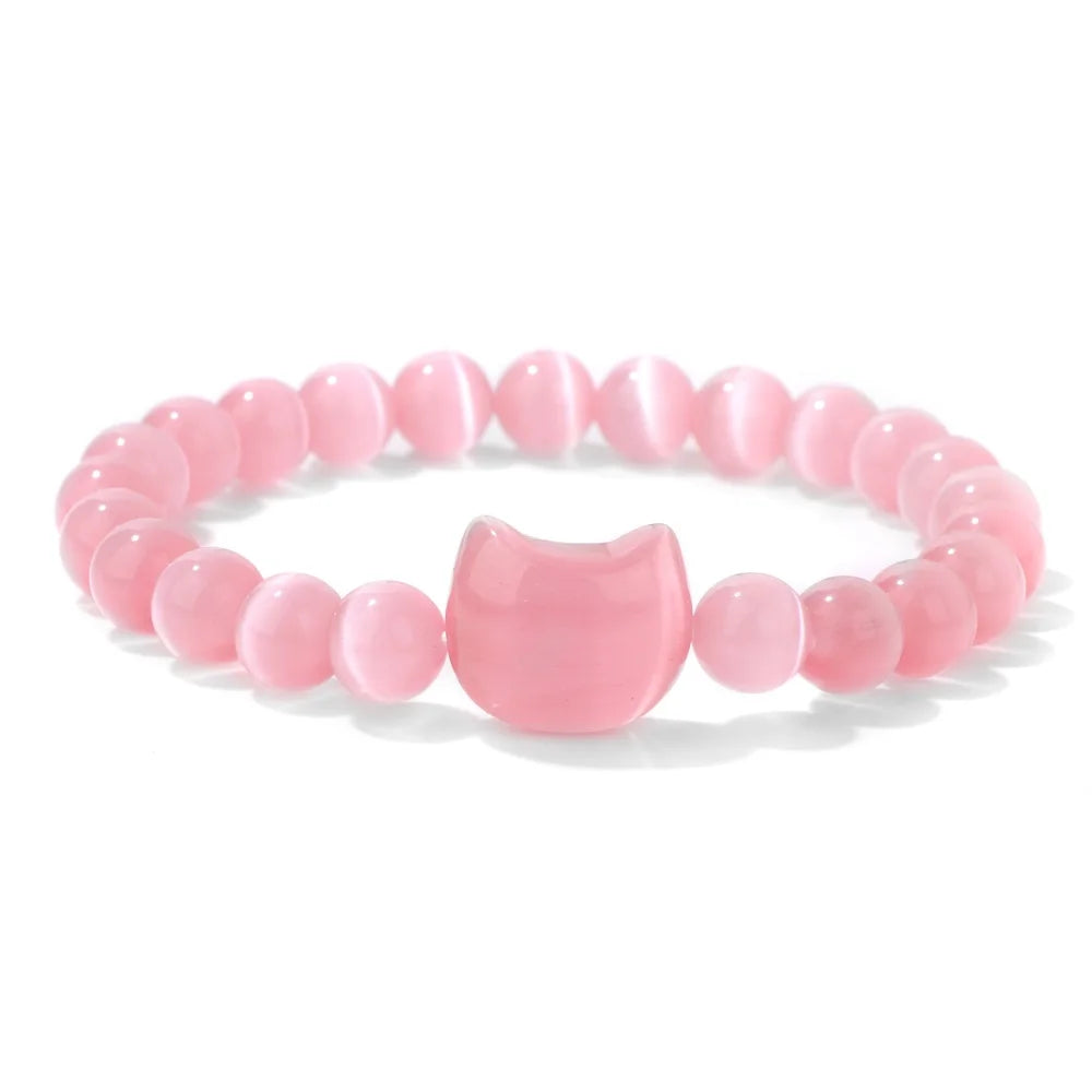 Pink beaded bracelet with a cat-shaped charm on a white background