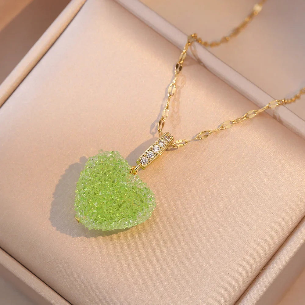 Green crystal pendant on a gold chain with a beige background