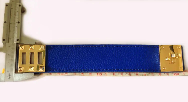 Blue leather strap bracelet with gold hardware on a white background, measured by a ruler.