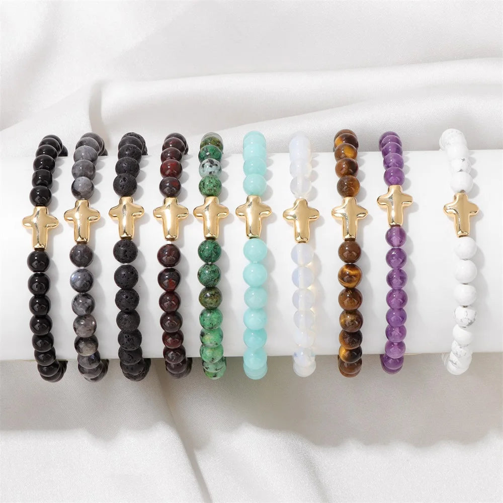 Set of beaded bracelets with cross charms on a white surface