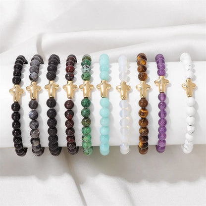 Set of beaded bracelets with cross charms on a white surface