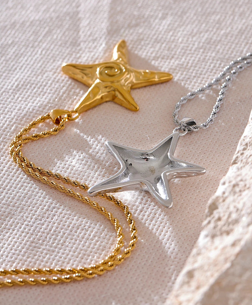 Star-shaped gold and silver pendants on a textured surface