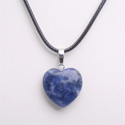 Heart-shaped blue stone pendant on a black cord against a white background