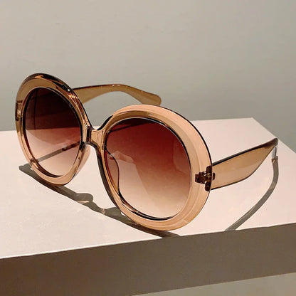Brown sunglasses with a gradient lens on a light surface