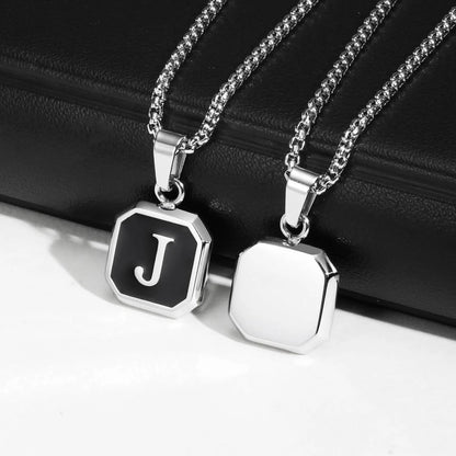 Two silver necklaces with hexagonal pendants on a black surface
