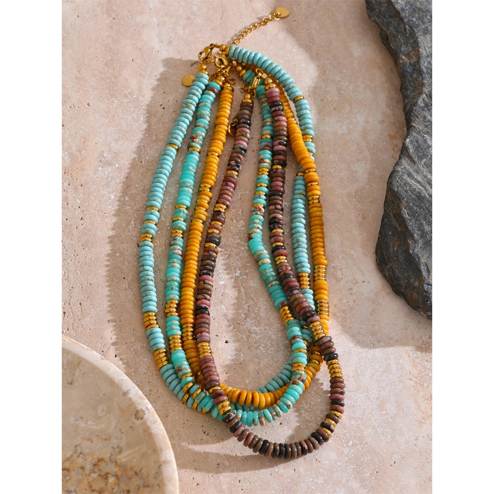 Multicoloured beaded necklace on a textured stone surface
