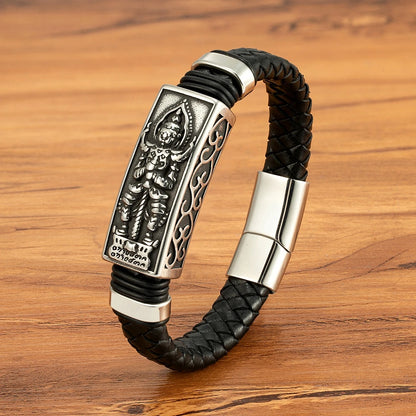 Black braided leather bracelet with silver metal clasp on a wooden surface