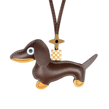 Brown dachshund-shaped keychain with a checkered bag charm on a white background