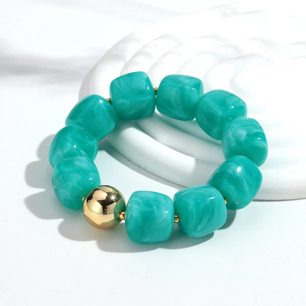 Turquoise beaded bracelet with a gold accent on a white background