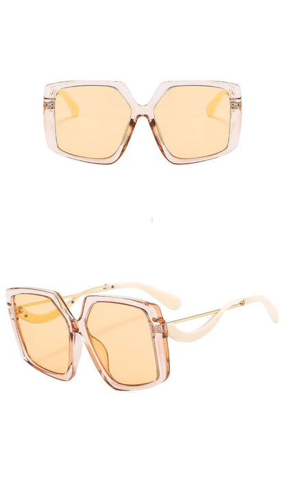 Two views of oversized square sunglasses with translucent champagne-coloured frames and warm yellow lenses on a white background.