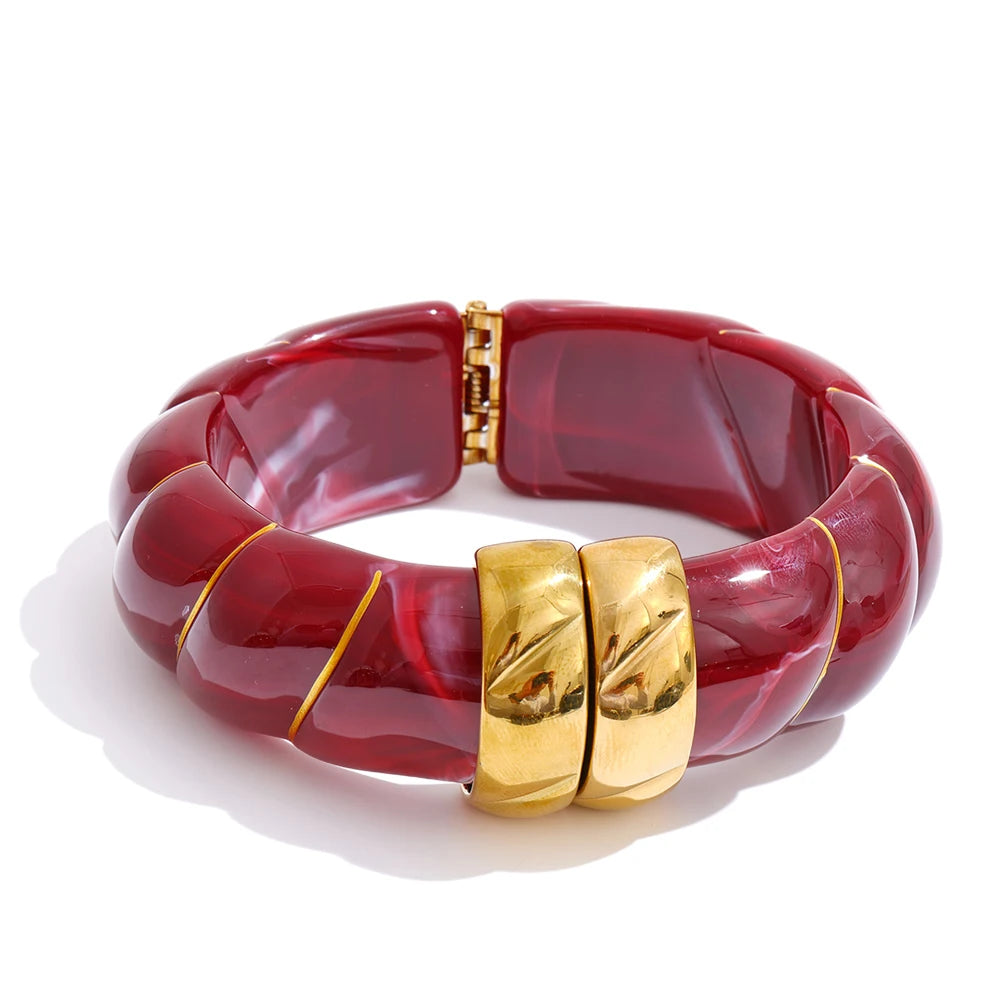 Red bracelet with gold accents on a white background