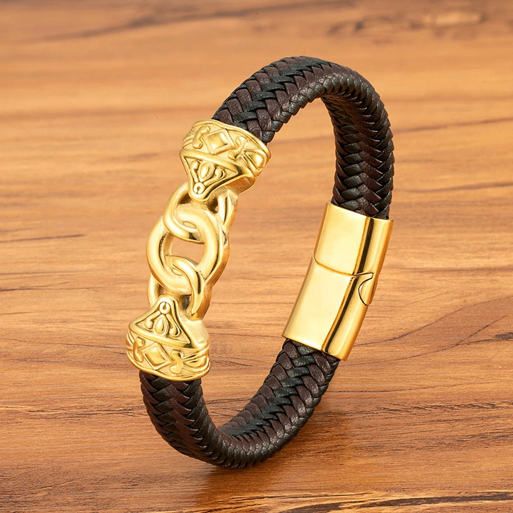 Brown braided leather bracelet with gold chain and clasp on a wooden surface