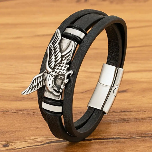 Black leather bracelet with silver eagle clasp on a wooden surface