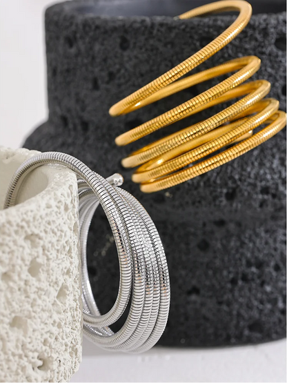 Gold and silver bangles on a textured black and white surface