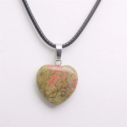 Heart-shaped stone pendant on a black cord against a white background
