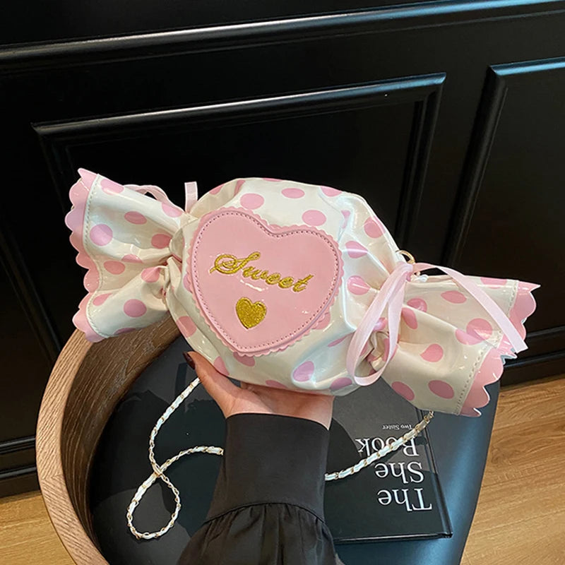 Polka dot candy-shaped bag with a heart detail and 'Sweet' text, held by a person.