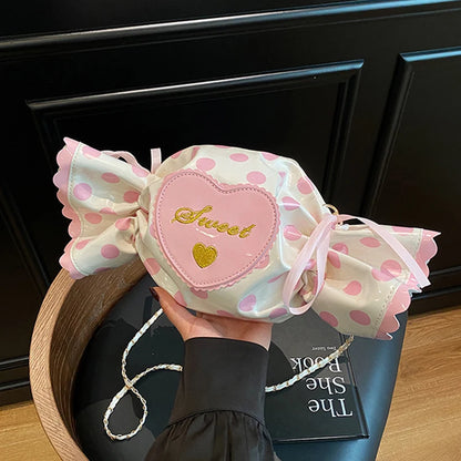 Polka dot candy-shaped bag with a heart detail and 'Sweet' text, held by a person.