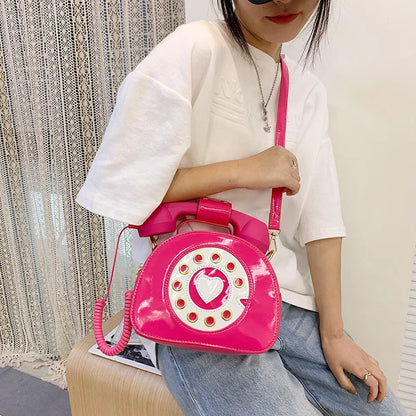 Person holding a pink phone-shaped handbag with a white background