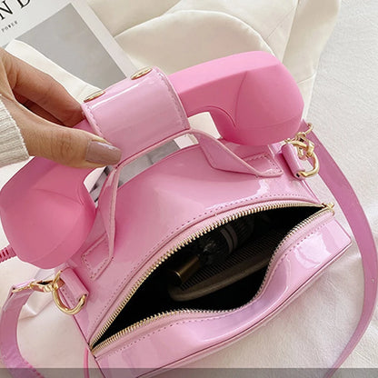 Pink handbag with opened top zipper on a white surface