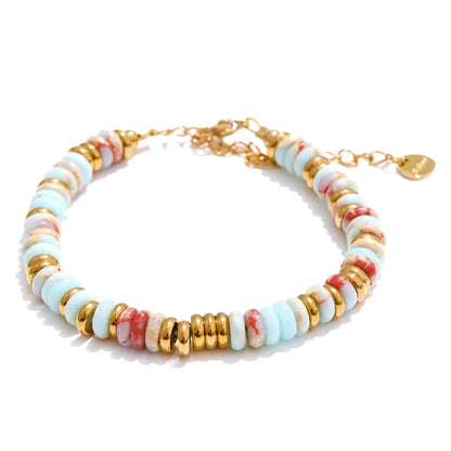 Multicoloured beaded bracelet with gold accents on a white background