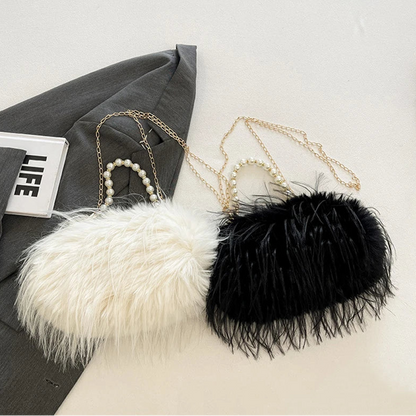 Two feathered handbags, one white and one black, on a light grey surface with a magazine titled 'LIFE' partially visible.