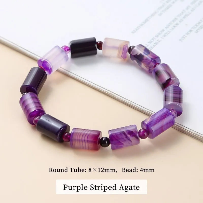 Purple striped agate beaded bracelet on a white surface
