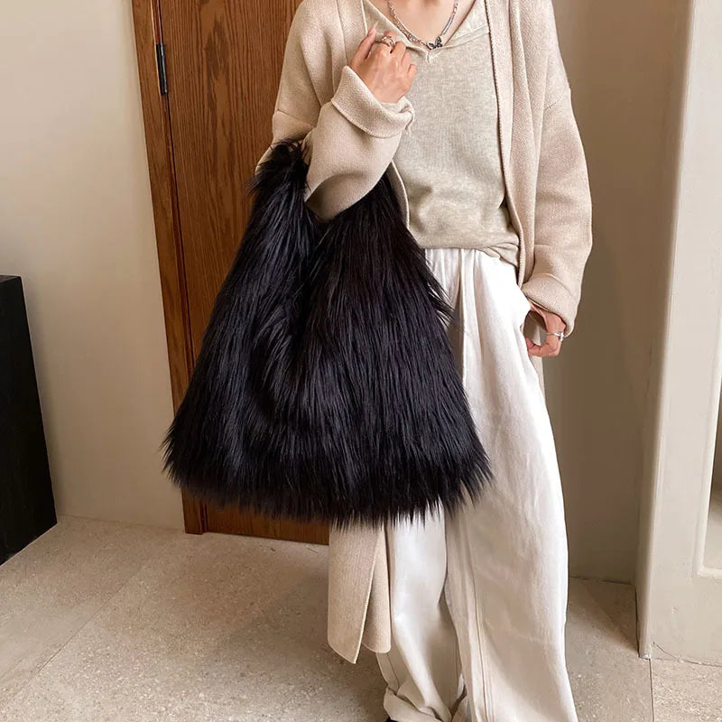 Person holding a black fluffy bag indoors