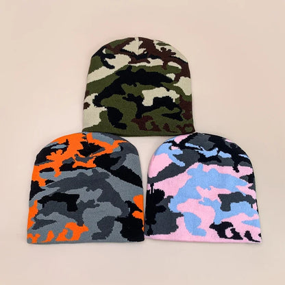 Three camouflage-patterned beanies in different colour schemes on a beige background