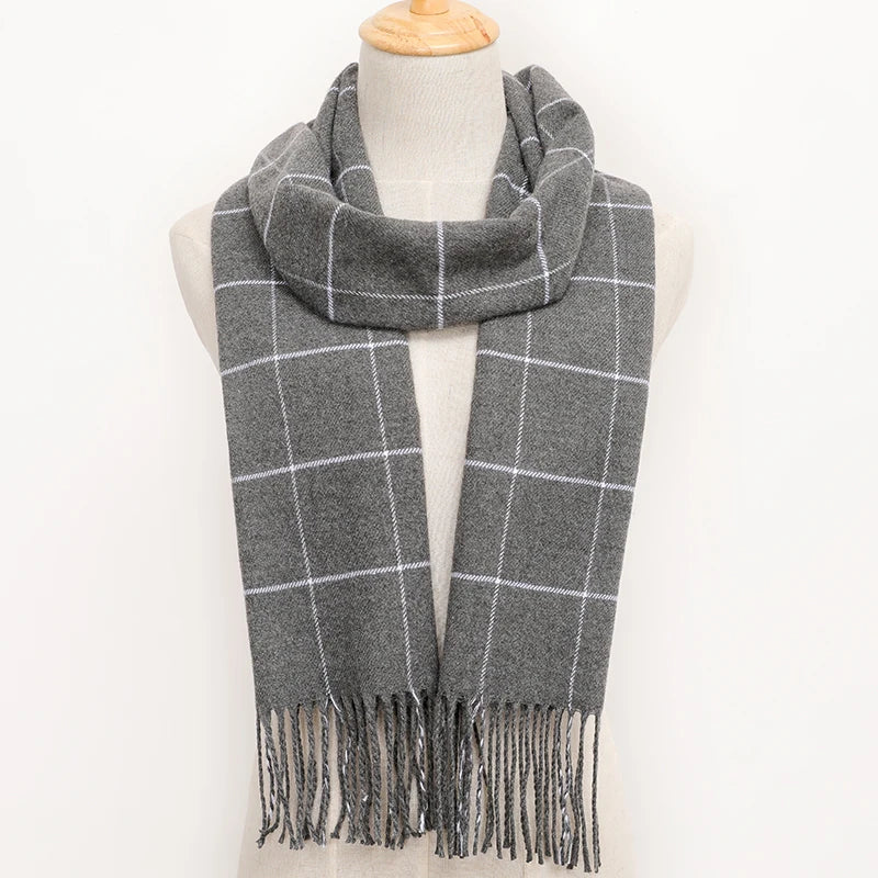 Grey plaid scarf with fringes on a mannequin against a white background
