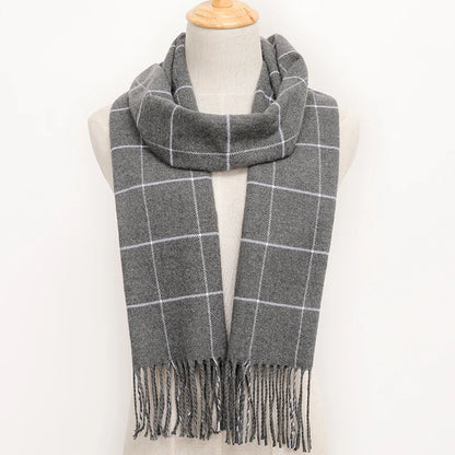 Grey plaid scarf with fringes on a mannequin against a white background