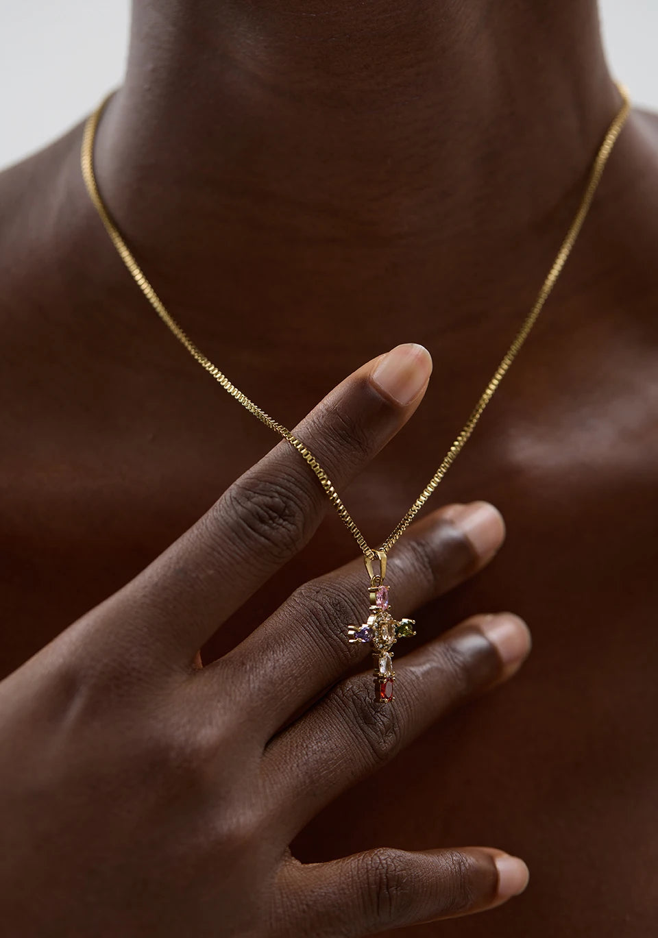 Gold necklace with a pendant worn by a person