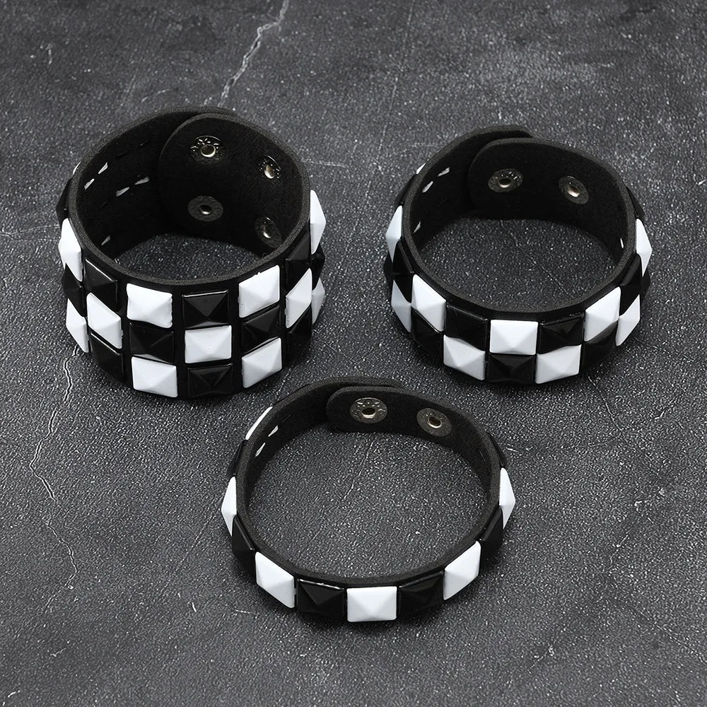 Three black and white checkered bracelets on a dark textured surface