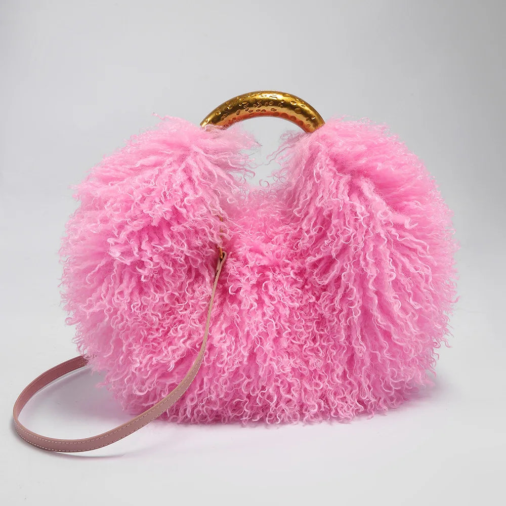 Pink fluffy handbag with a gold handle on a light grey background