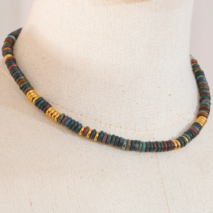 Necklace with multicoloured beads on a mannequin neck.