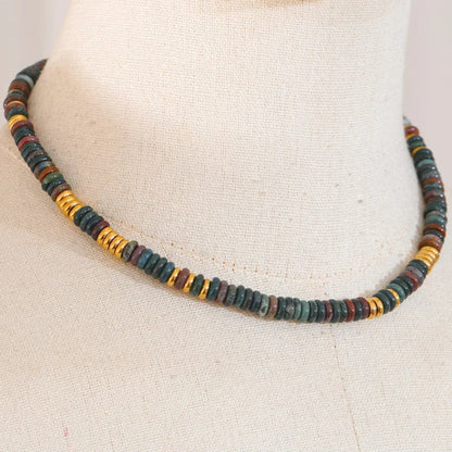 Necklace with multicoloured beads on a mannequin neck.