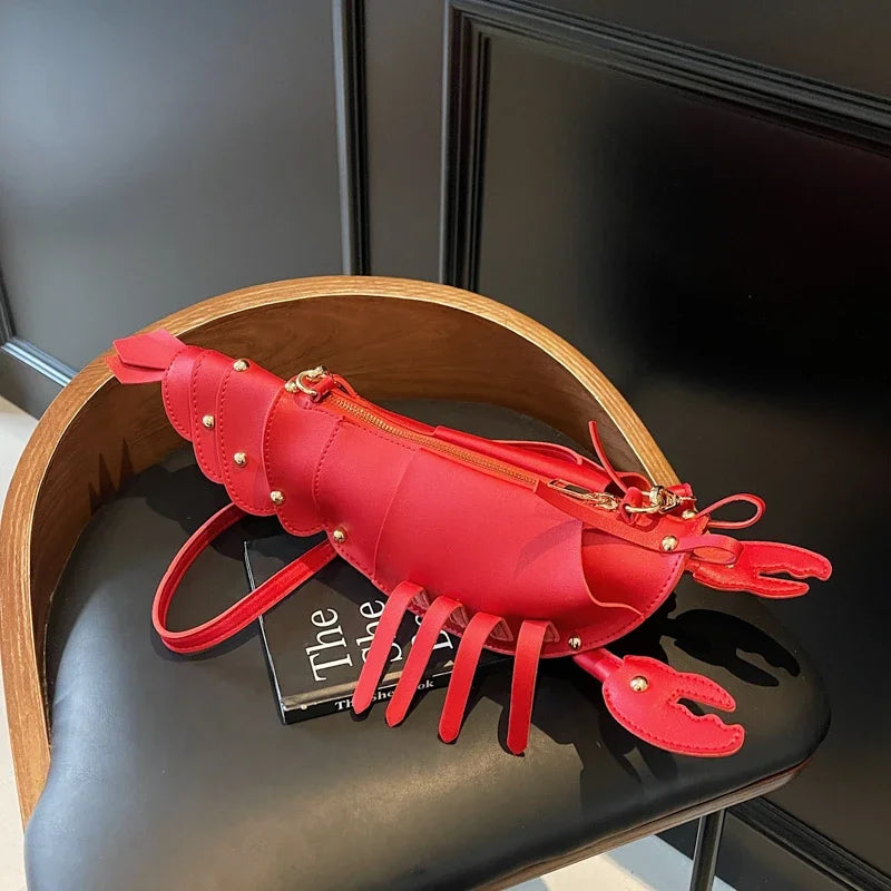 Red lobster-shaped handbag on a black chair