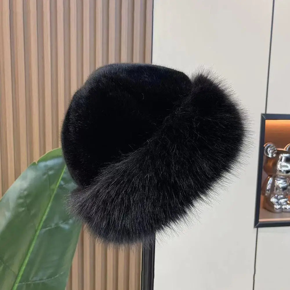 Black fur hat on a surface with a plant in the background