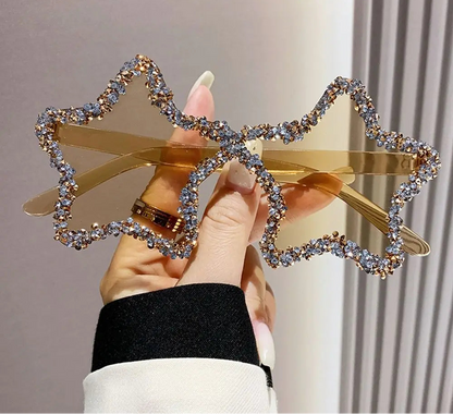 Star-shaped hair clip with rhinestones held by a hand against a neutral background